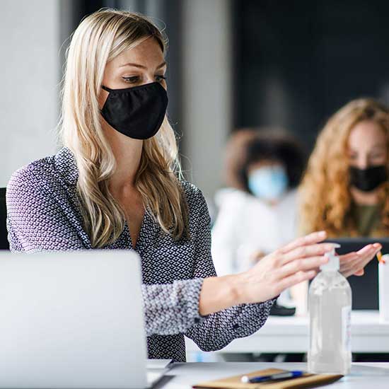 woman with mask and hand sanitizer
